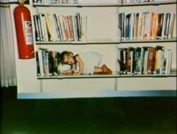 Young girl hiding on shelf, Casuarina Public Library, 1982.