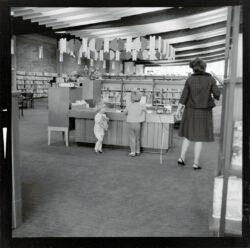 Two children and woman at counter, Gisborne Public Library, Gisborne Public Library between ca 1962 and 1970.