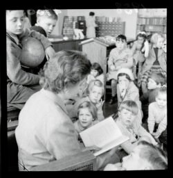 Unidentified woman reading a book to children at story time at the Wellington Public Library, 1958.